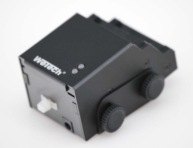 Appareil électronique noir avec deux cadrans et interrupteurs blancs.