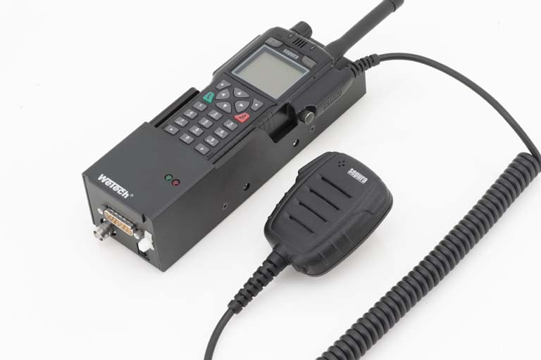 Radioapparaat met microfoon, kabel aangesloten, op witte achtergrond.