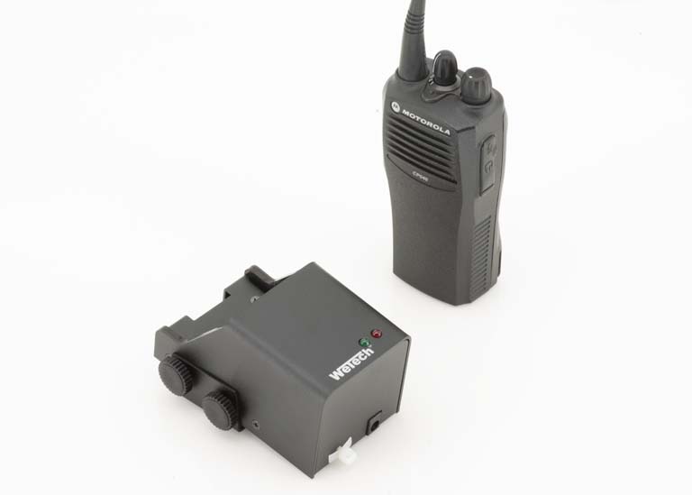 Talkie-walkie et appareil électronique noir avec boutons de contrôle sur fond blanc.