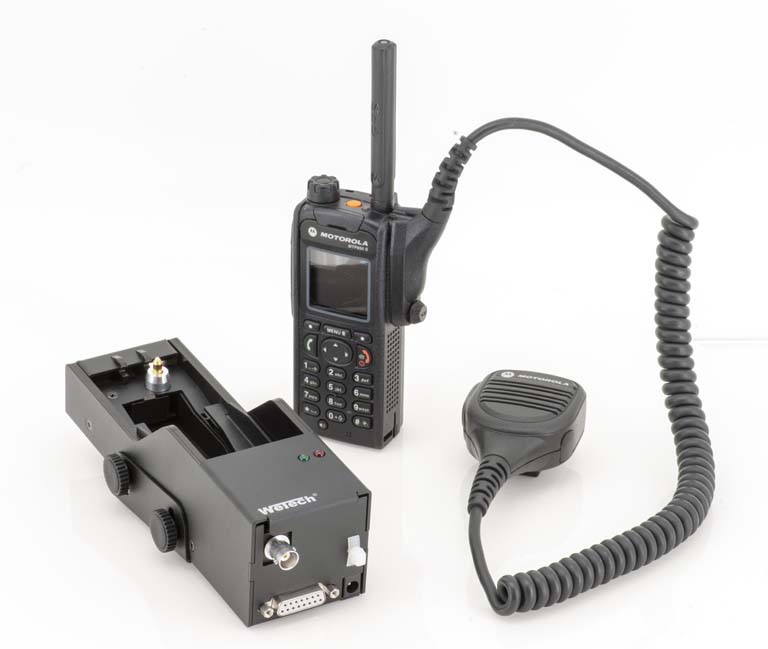 Radio met microfoon en oplader op lichte achtergrond.