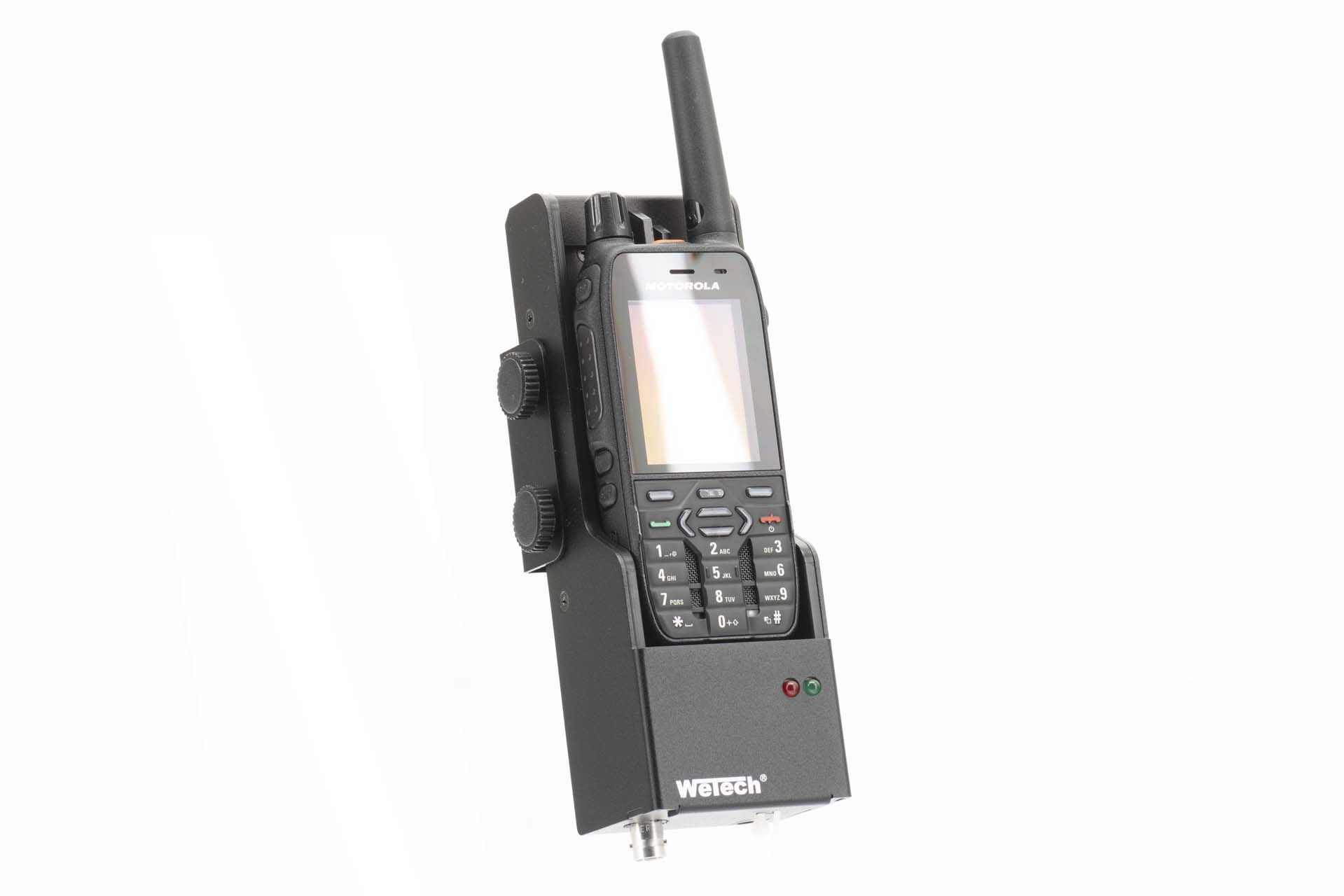 Walkie-talkie with antenna, display, and buttons mounted on black-gray holder.