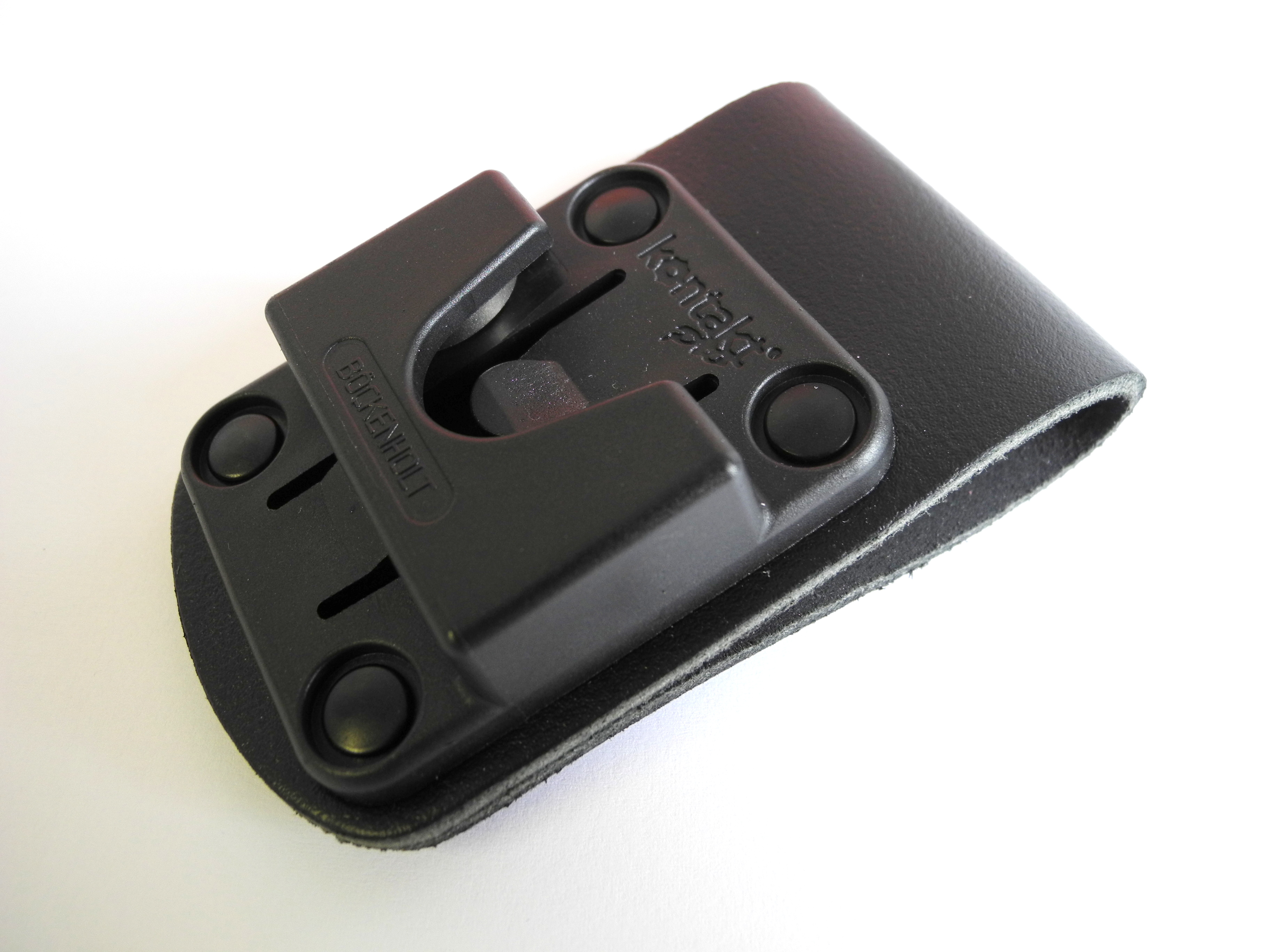 Zwarte riemclip met vier klinknagels en een houder.