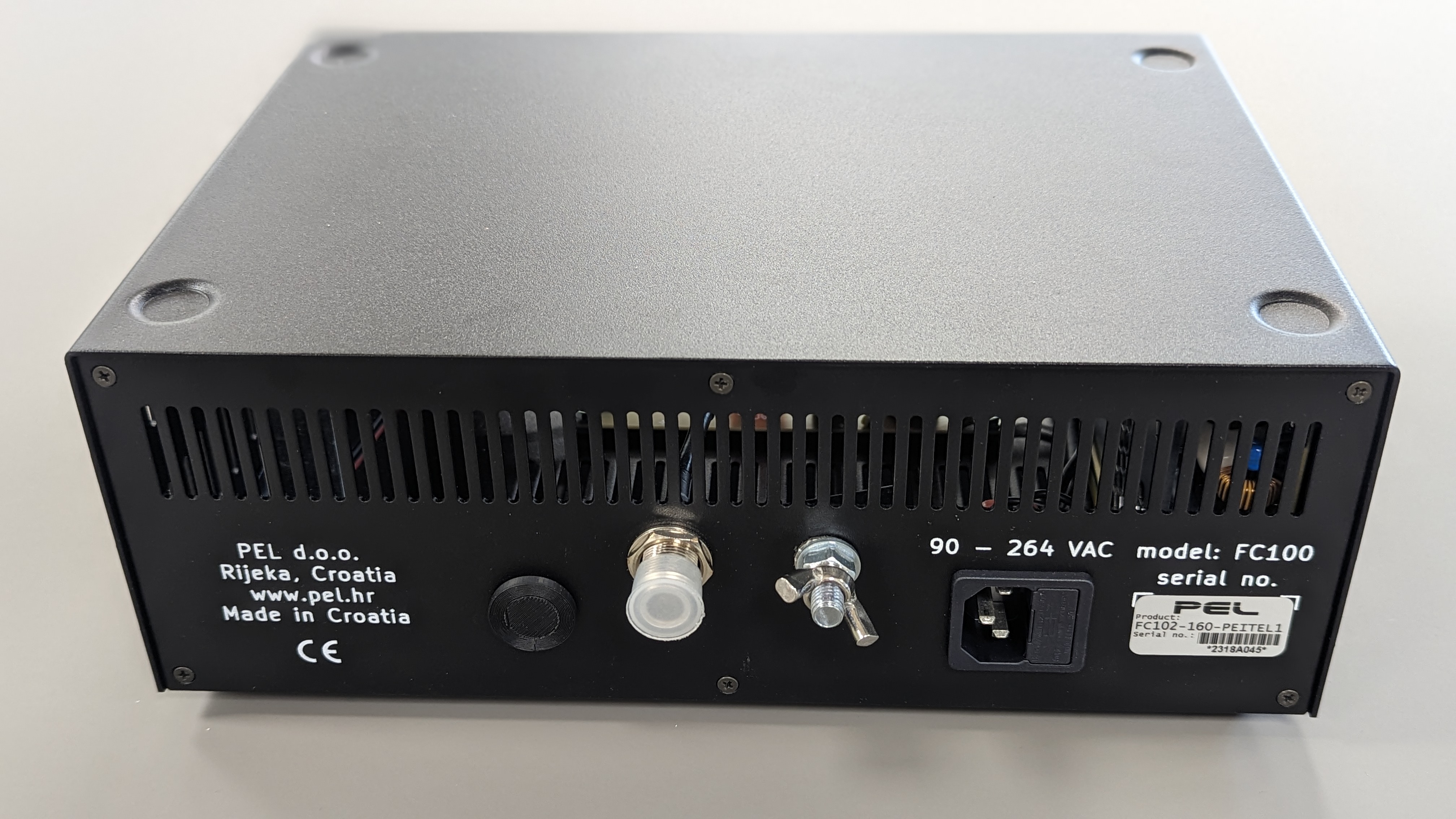 Appareil électrique noir avec connecteurs et étiquette de numéro de série.