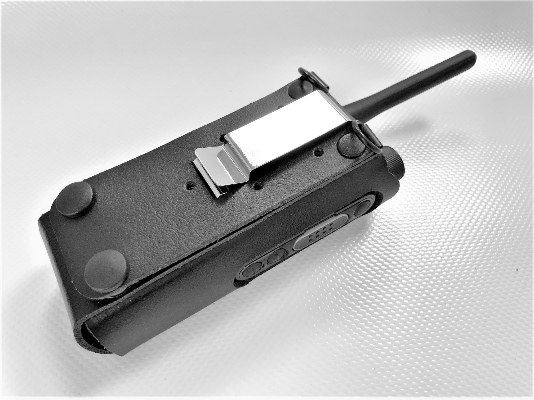 Radio portable dans un étui en cuir noir avec antenne.