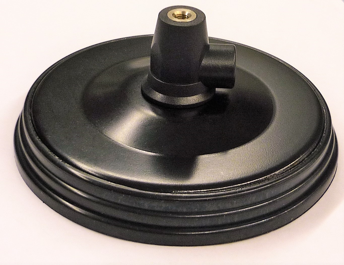 Zwarte ronde metalen voet met beugel bovenop.