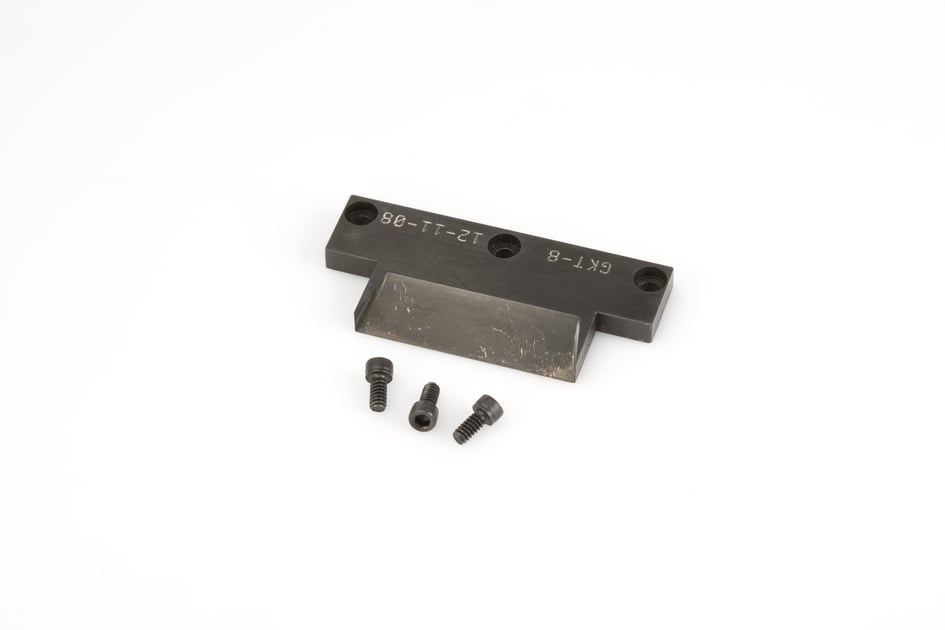 Black metal part with three small screws on white background.