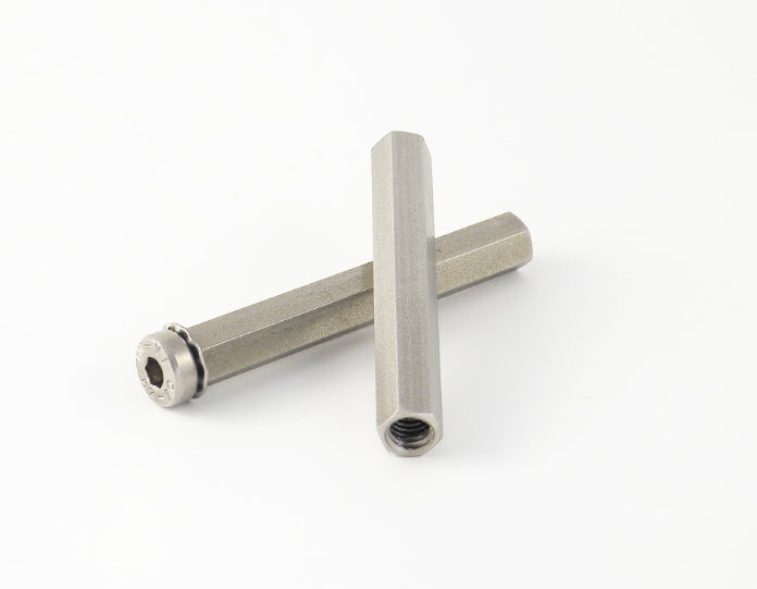 Two silver hex standoffs, one lying across the other.