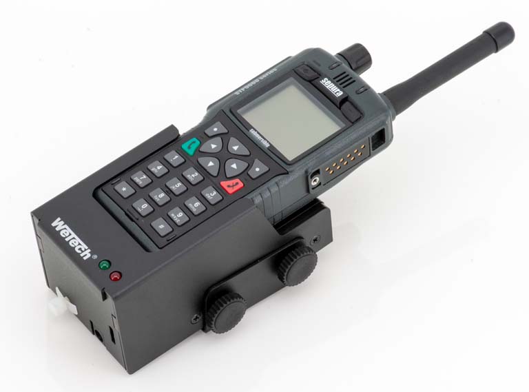 Handheld radio with charger and antenna on white background.