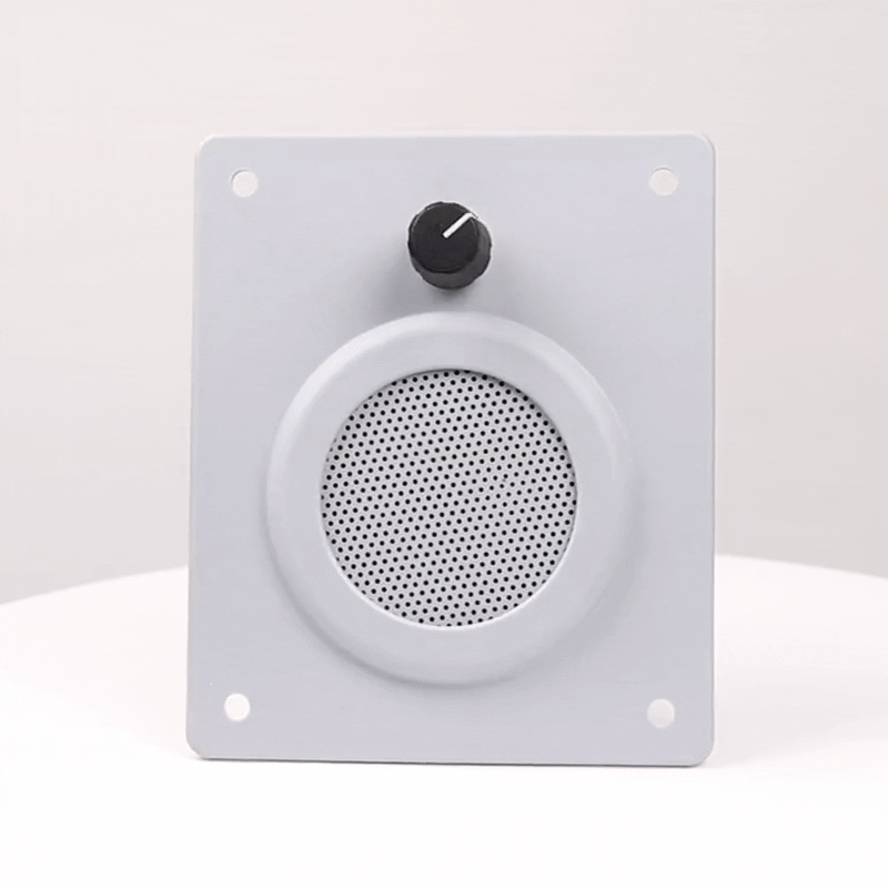 Haut-parleur blanc avec bouton de volume sur panneau carré.