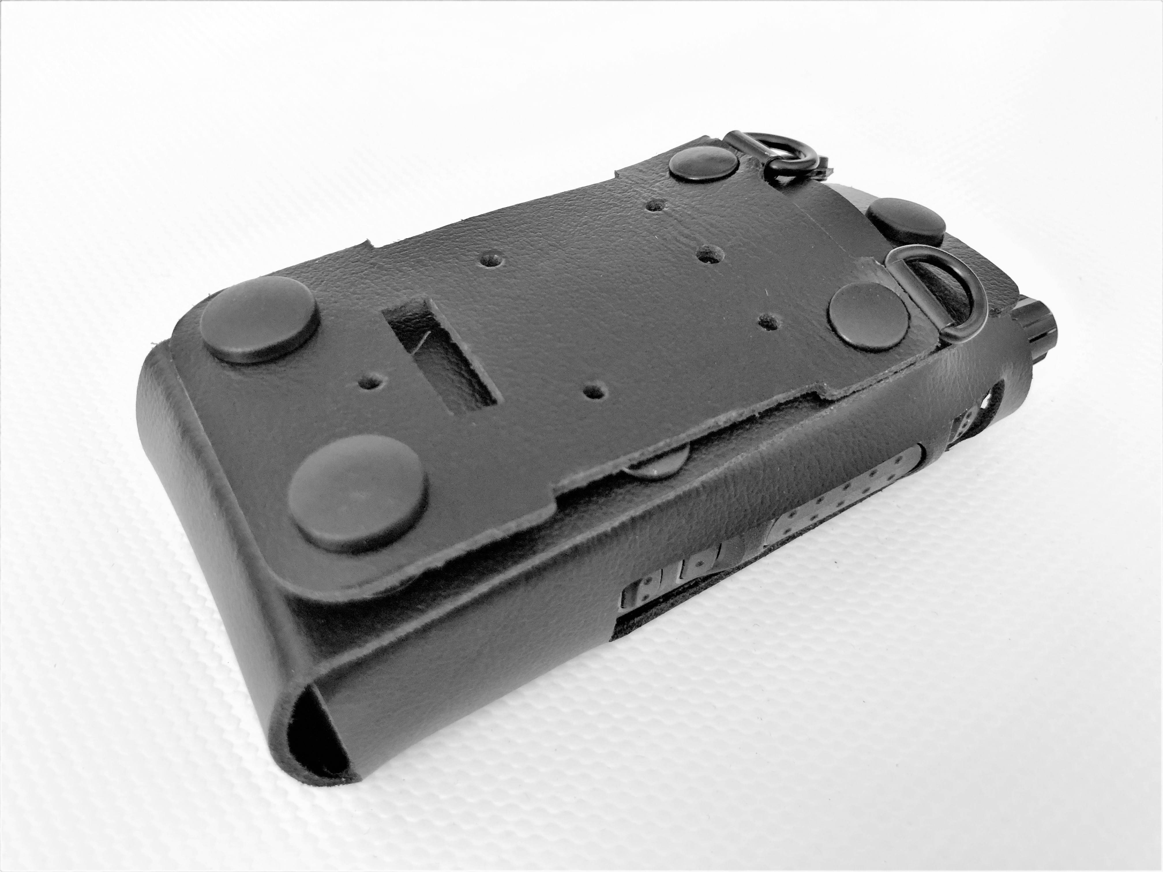 Black rectangular metal holder with rivets and rings.