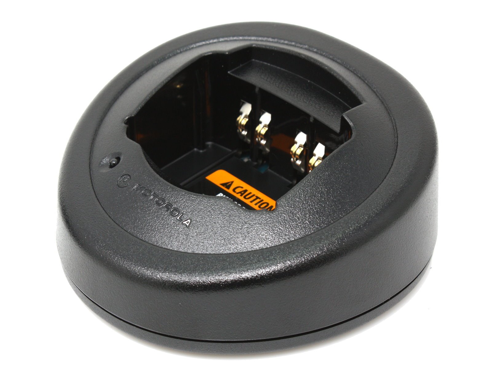 Round, black charging dock for electronic devices with metal contacts and caution label
