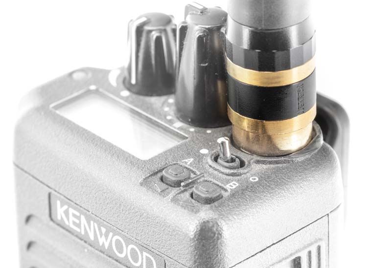 Close-up of a radio device with antenna, switches, and knobs.