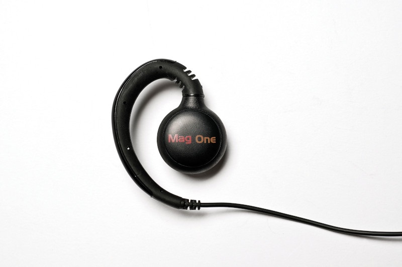 Een zwarte oortelefoon met kabel en Mag One-logo.