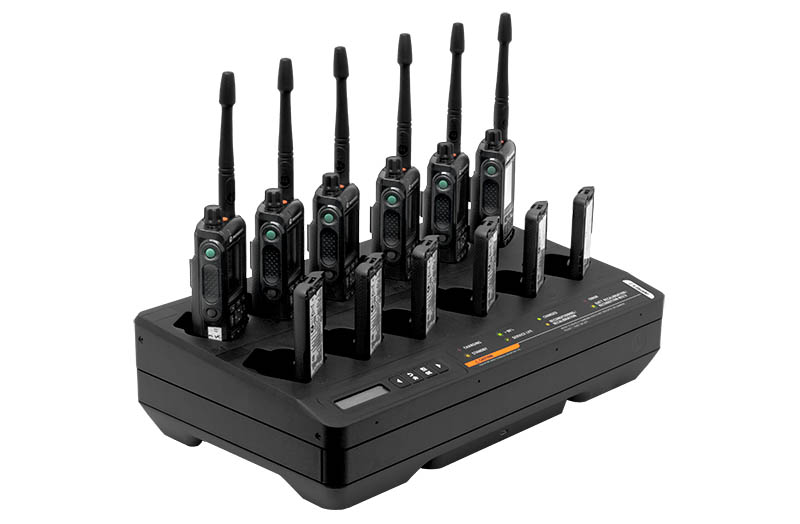 Chargeur avec huit radios dans les emplacements, voyants allumés.