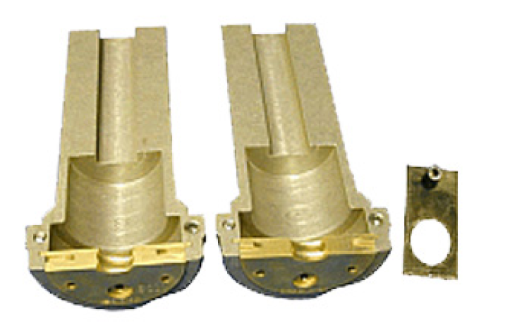 Two gold valve bodies and a small rectangular plate with a hole.