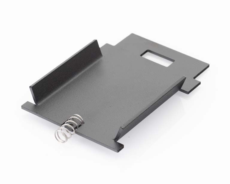 Rechthoekige metalen plaat met veer aan één kant, uitsparing zichtbaar.