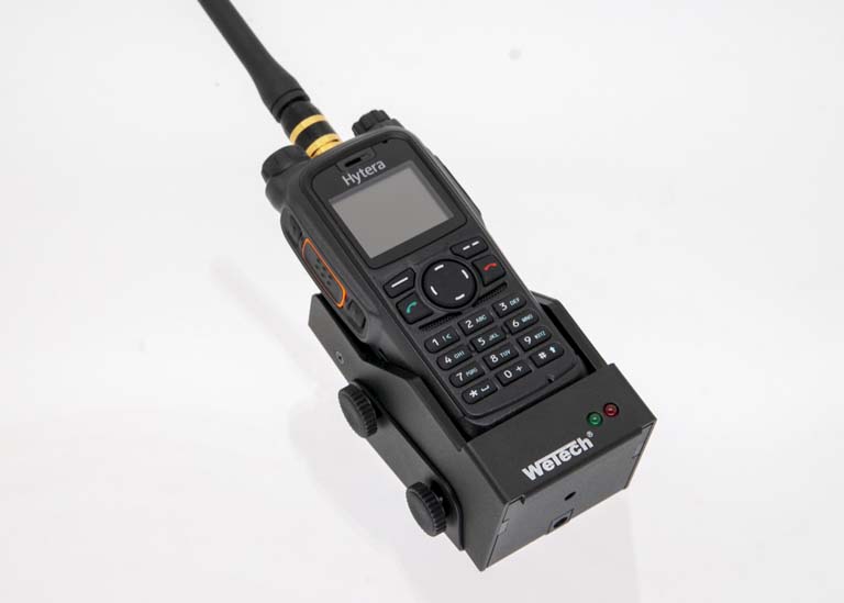 Handradio op zwarte houder met antenne en toetsenbord.