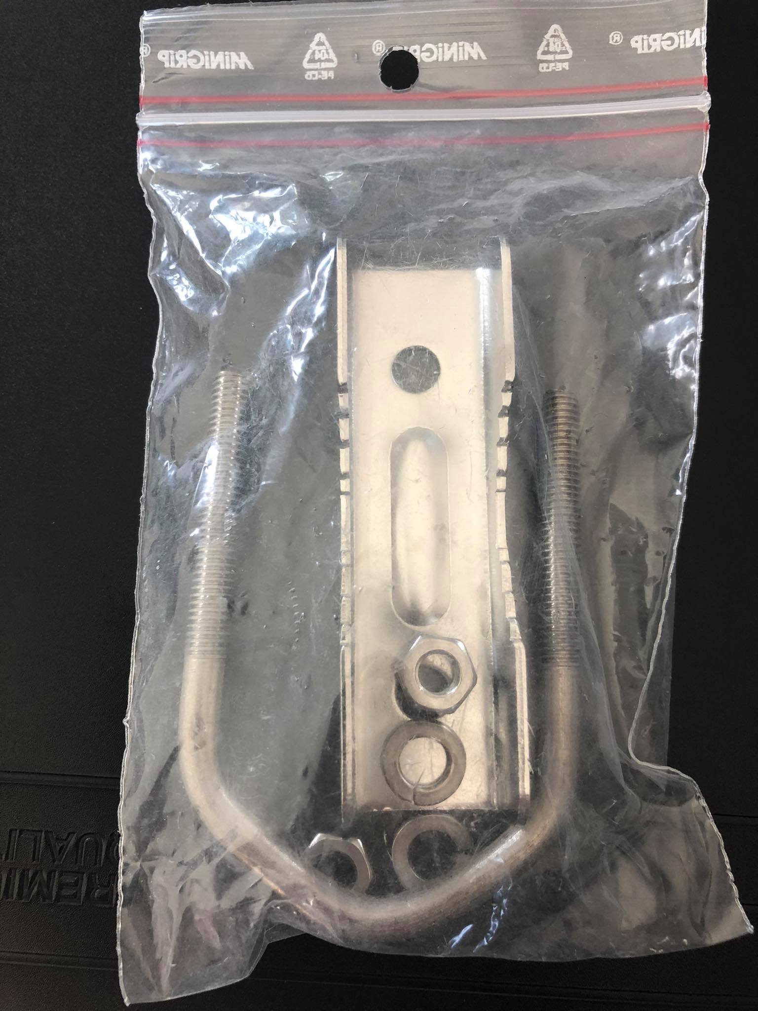 Boulon en U en métal avec vis dans un sac plastique.