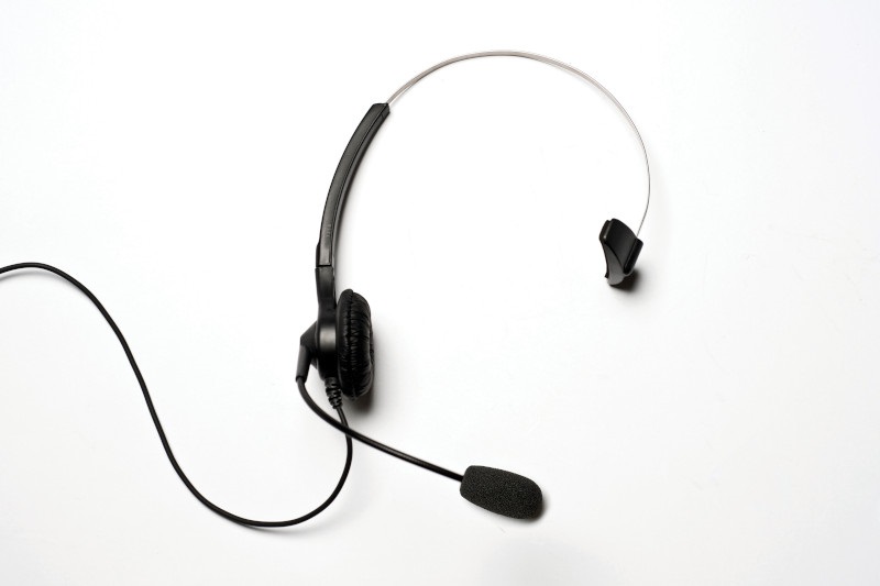 7000-00367100_mot_01.jpg Een zwarte headset met microfoon en één oordopje op een witte achtergrond.