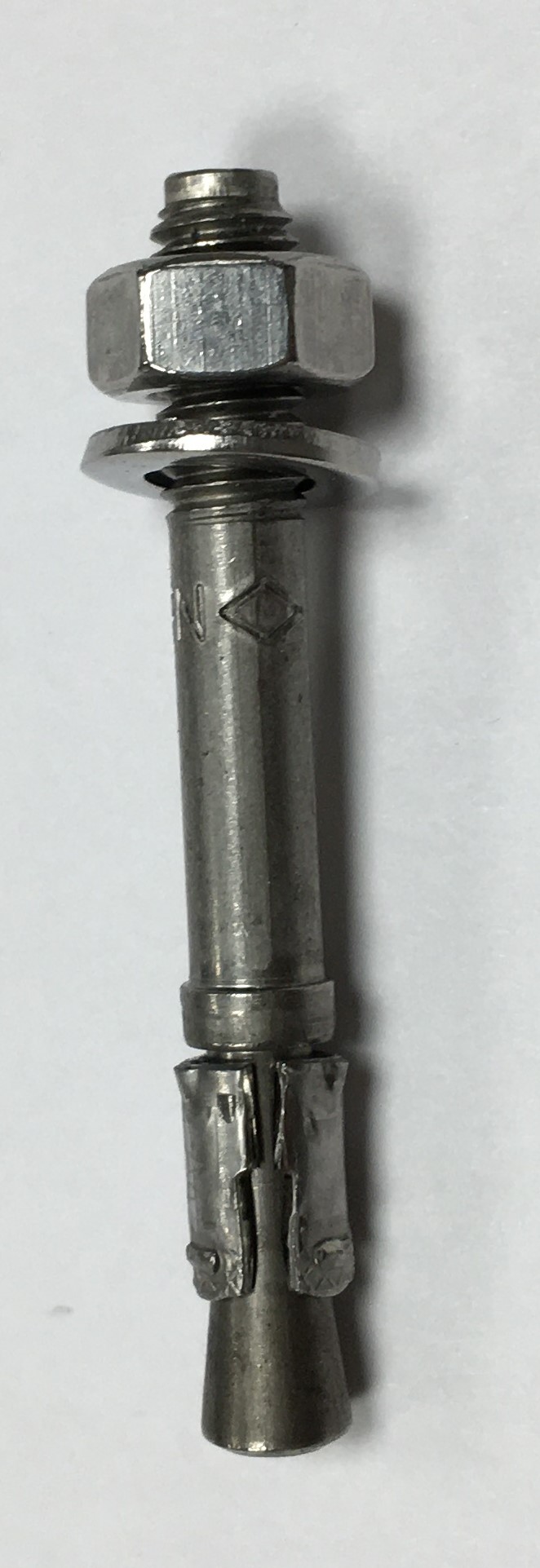 Metal expansion anchor with hex nut and washer on white background.