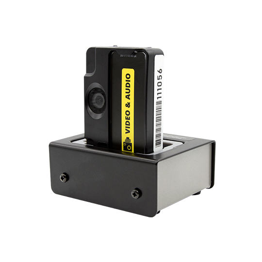 Kleine zwarte camera in dockingstation met gele video- en audiosticker.