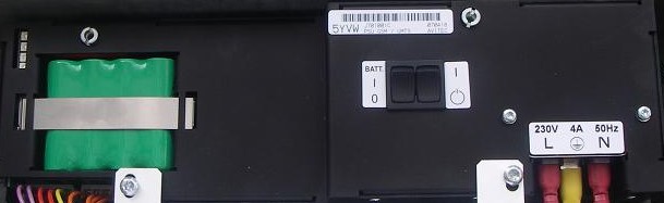 Appareil électrique avec batterie verte, interrupteurs et bornes.