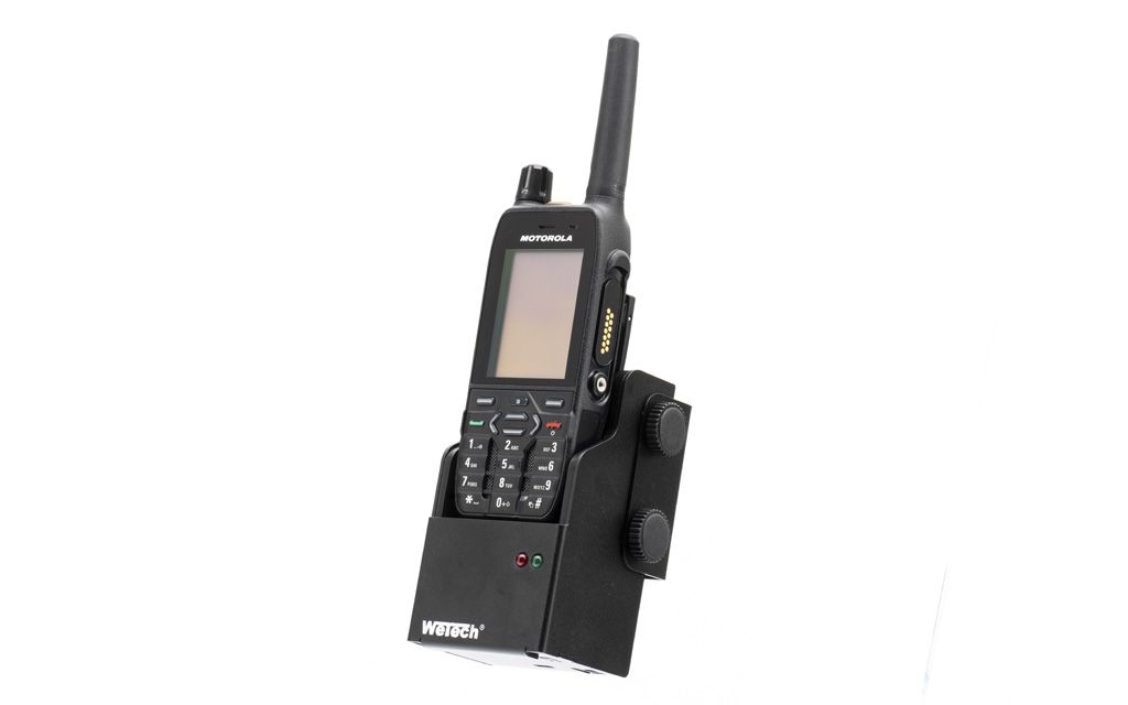 Zwart handheld radio met antenne en knoppen in oplader.