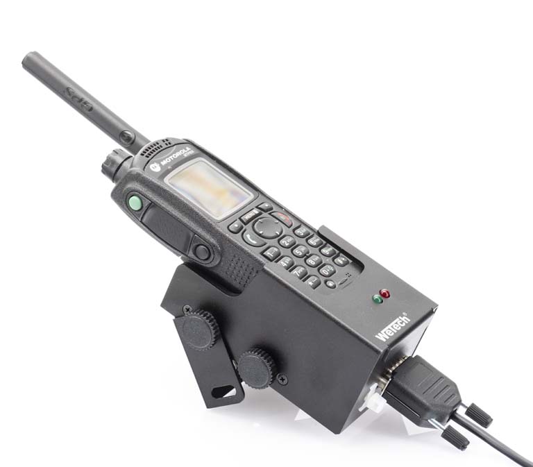 Radio met antenne in houder. Verschillende knoppen en een display zichtbaar.