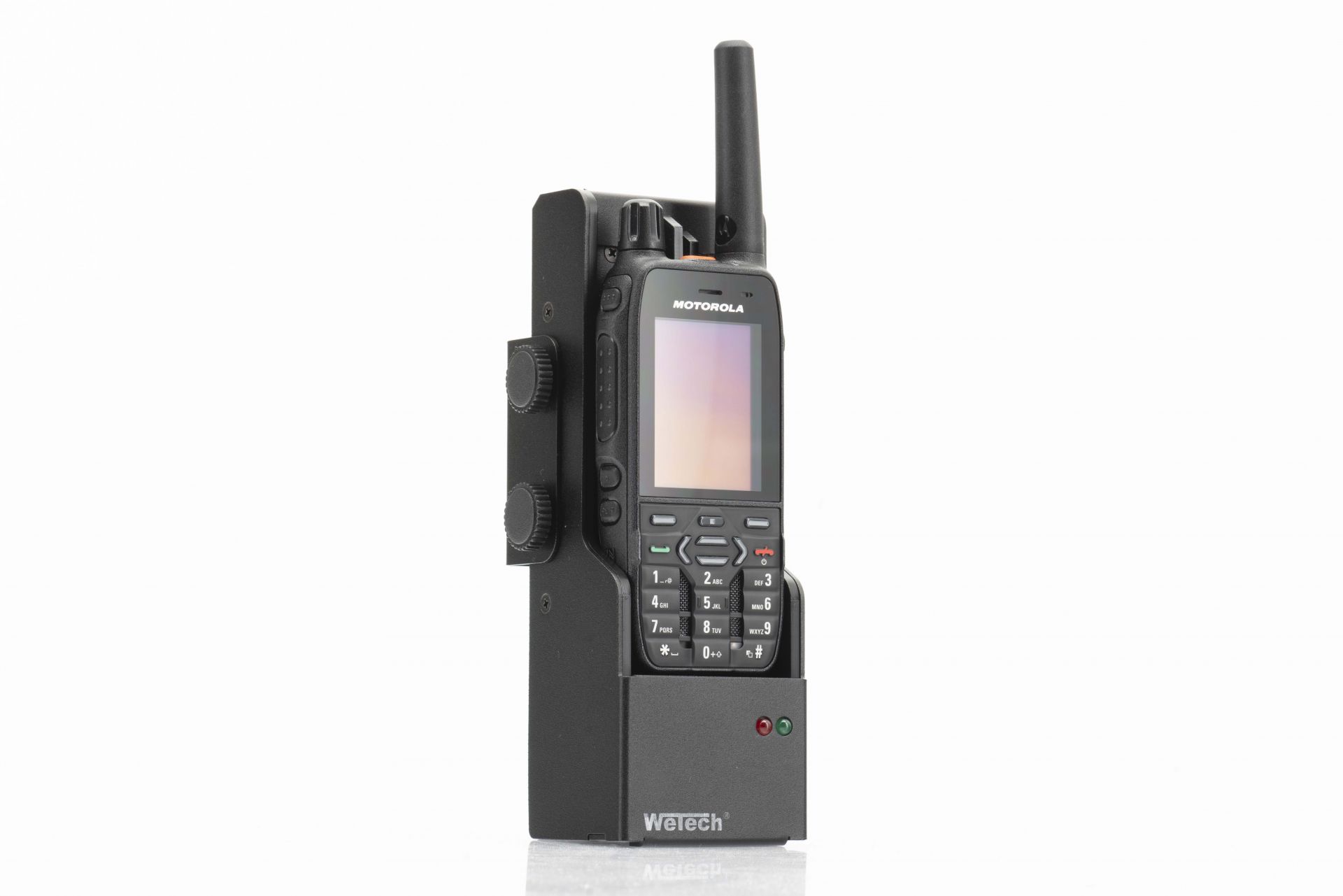 Portable radio with antenna and buttons, partially in a holder.