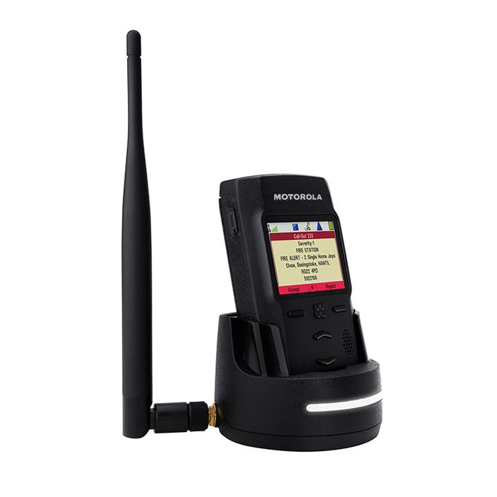 Radiopager met antenne in laadstation, scherm toont verzendgegevens.